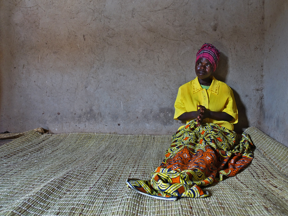 A woman with a disability in Rwanda, confined to a cramped, dark room.