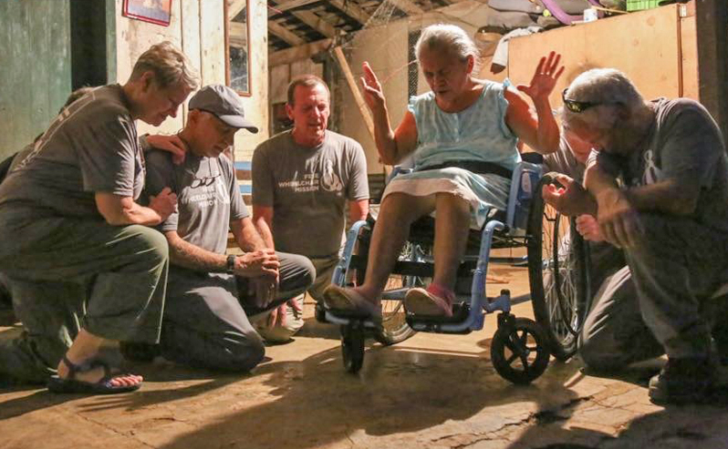 A team from Idaho prays for a wheelchair recipient in NIcaragua.