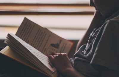 A boy reads a kid's book.