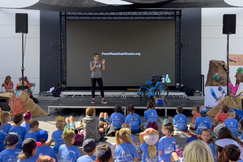 Children listening to a stage presentation by Free Wheelchair Mission.