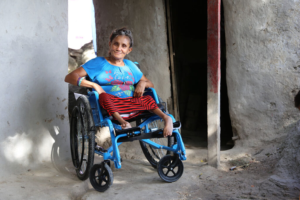 A woman sits in her wheelchair outside of her modest home in Nicaragua.