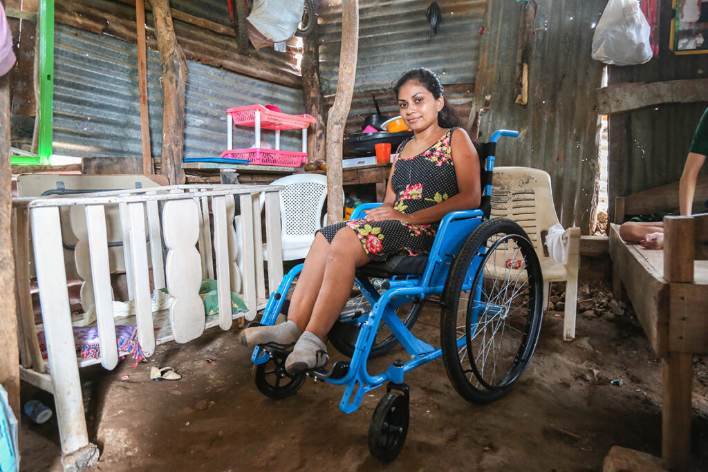 A young woman sits in her wheelchair inside her rural home in Nicaragua.