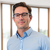 Headshot of a man wearing glasses, wearing a collared shirt.